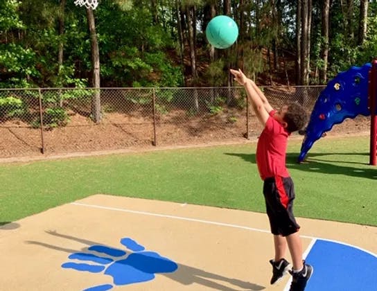 Child jumping to shoot a basketball