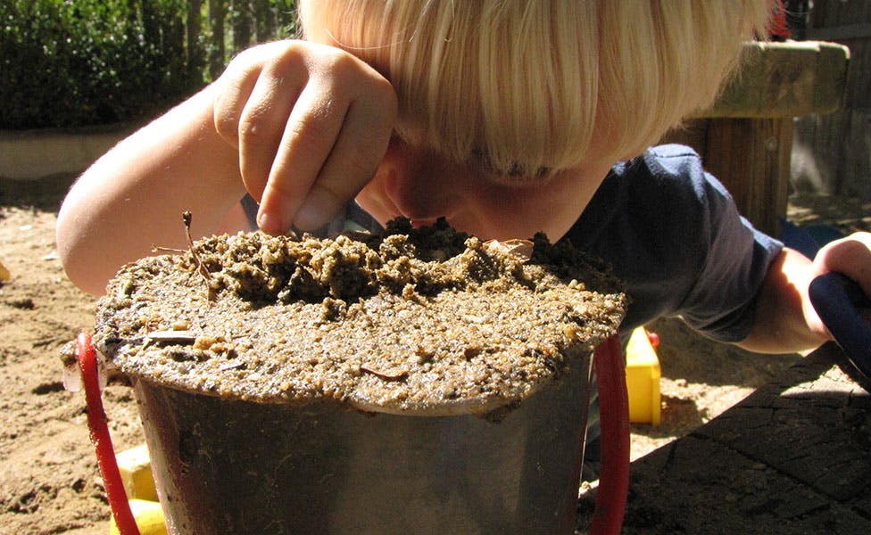 Child playing with sand in a bucket