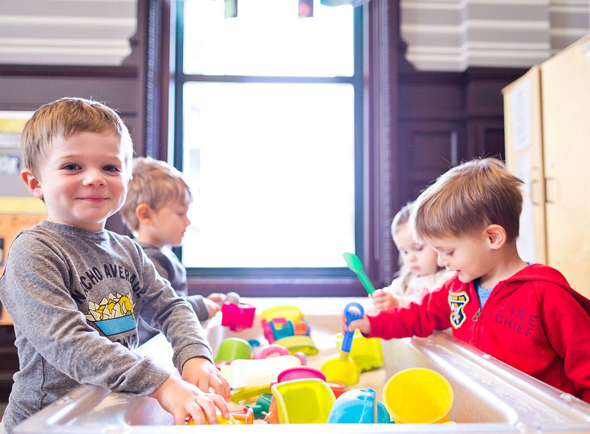 Children playing with toys in a sensory table