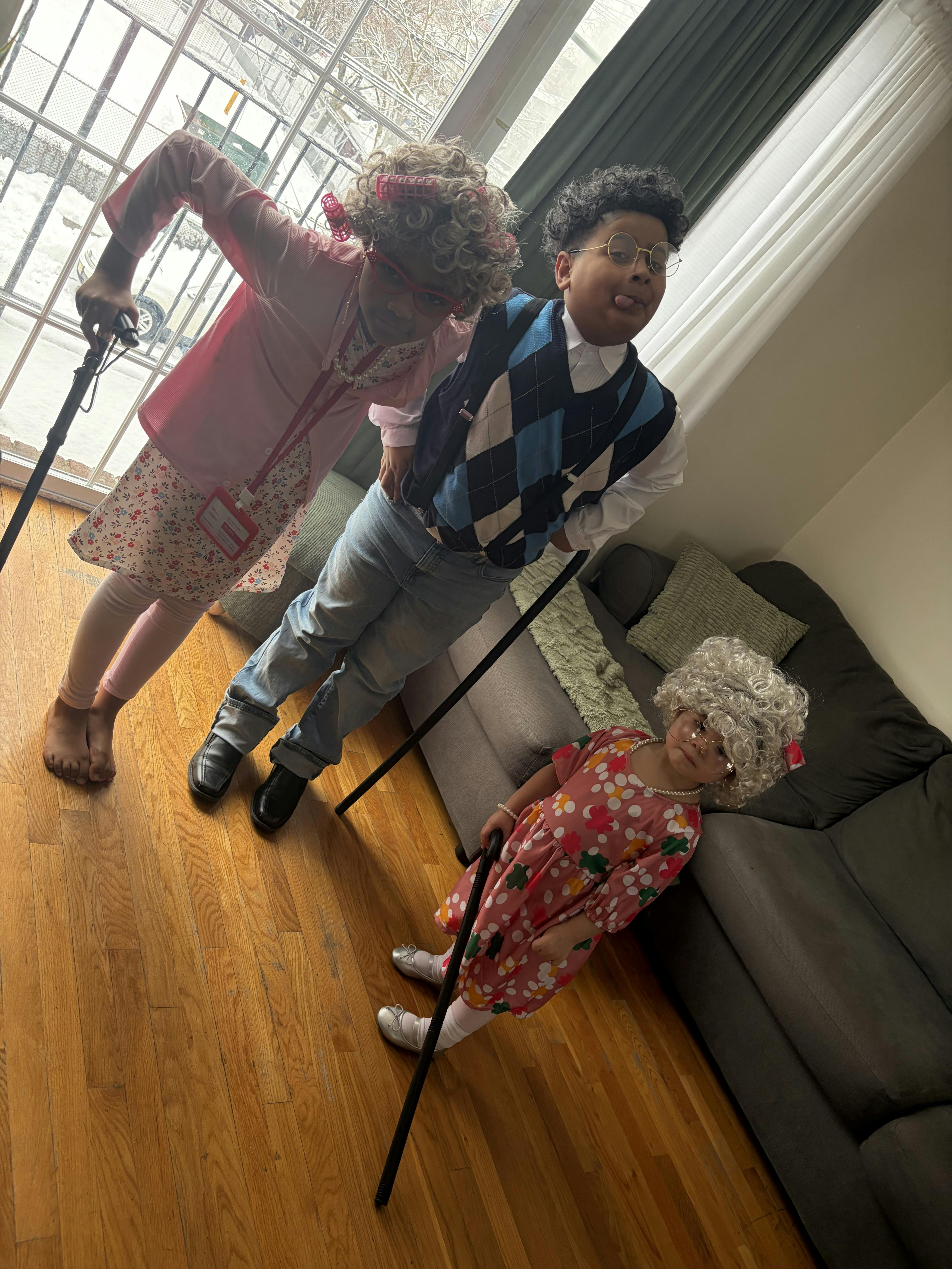 Three children dressed in "old people" costumes with canes