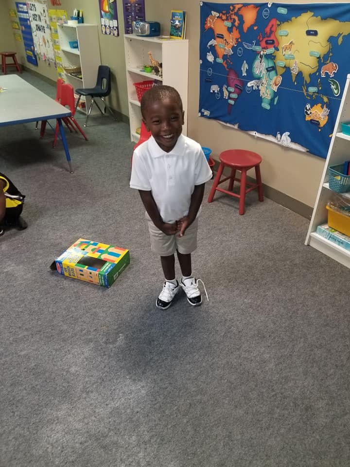 Child standing in a classroom