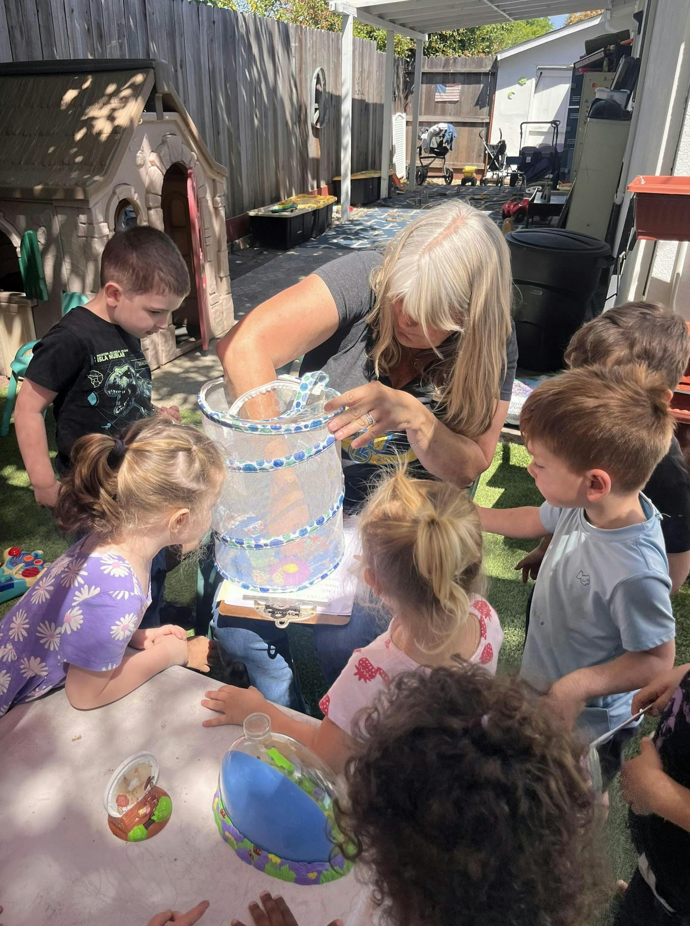 Adult and children gathered around a mesh container