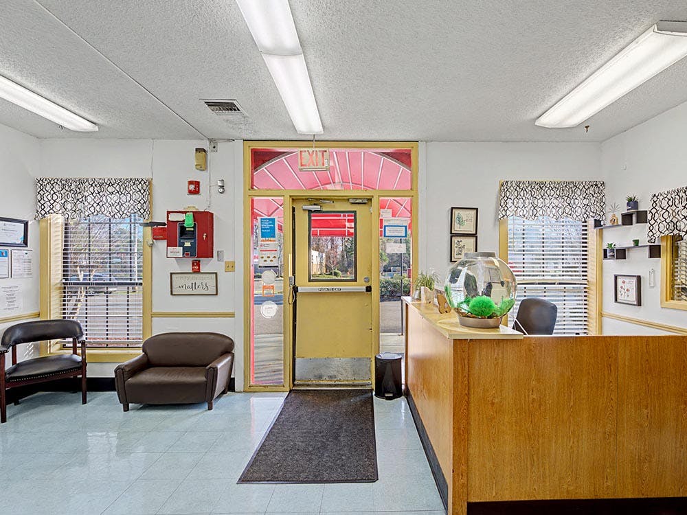 Entrance to a building with a reception desk, chairs, and an exit sign