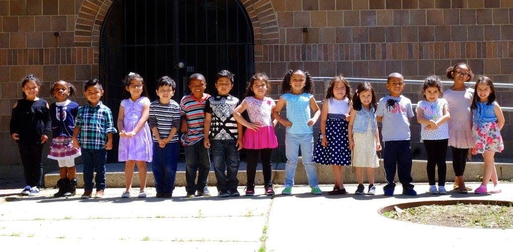 Group of children and one adult standing in a line