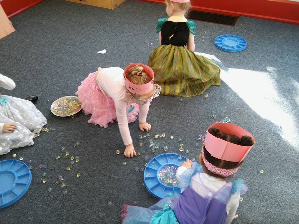 Children playing on the floor with small objects