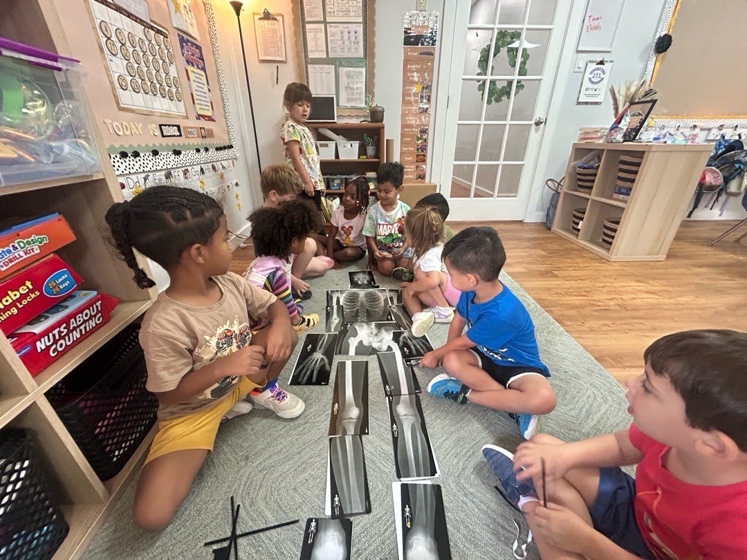 Children sitting on the floor looking at x-ray images