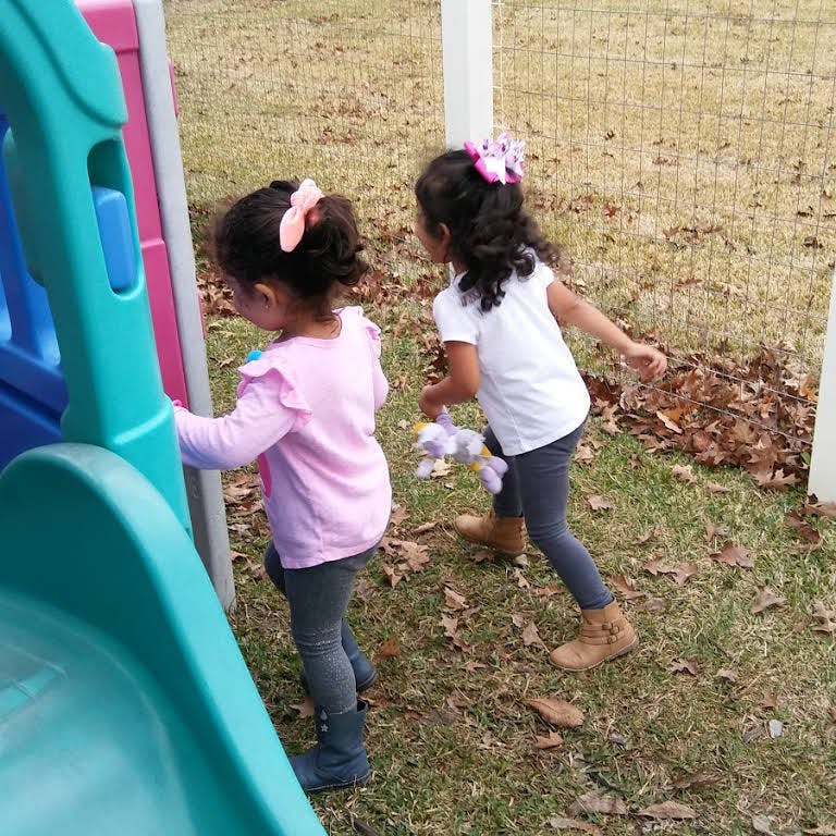 Two children playing near a slide