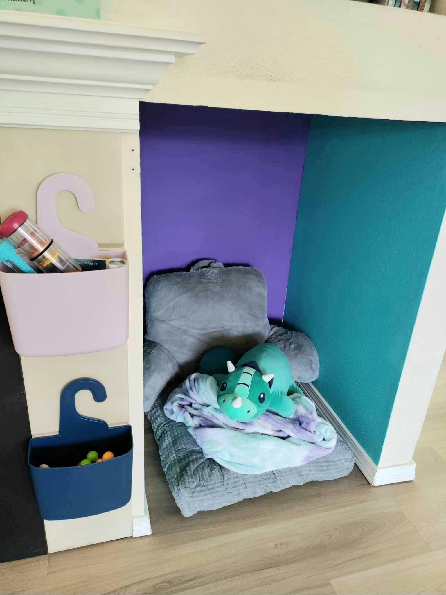 Stuffed animal on a gray chair next to wall-mounted storage bins