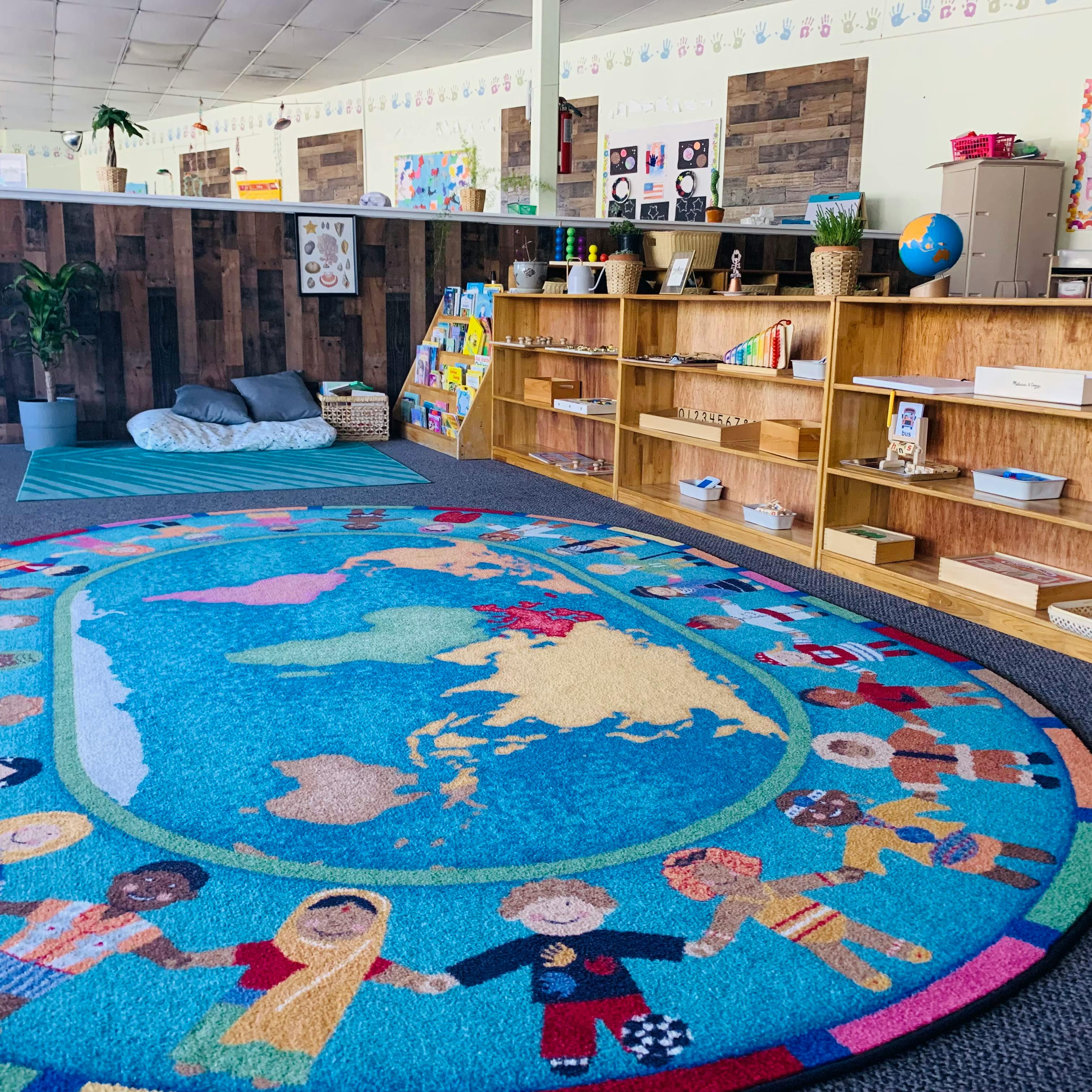 Classroom with a world map rug and shelves of children holding hands