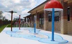 Water park splash pad with mushroom water feature