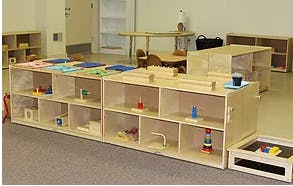 Montessori classroom with wooden shelves and learning materials