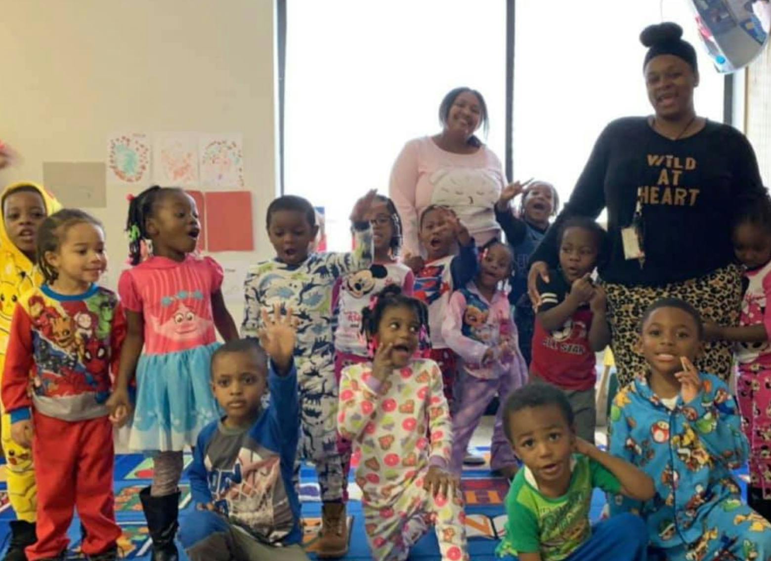 Two adults and a group of children in pajamas
