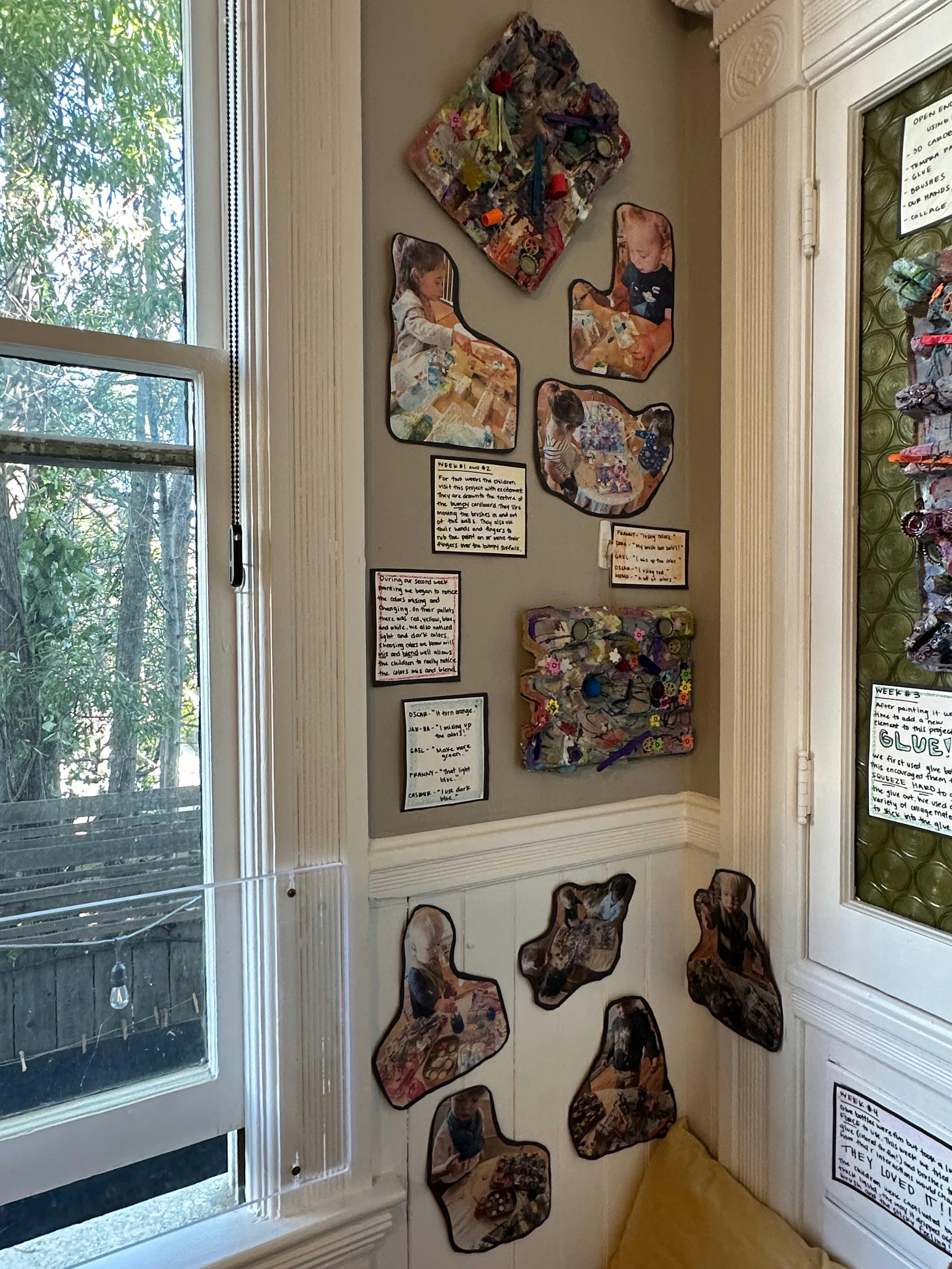 Wall display with various art pieces and text next to a window