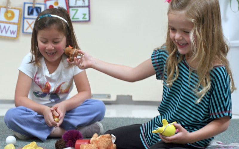 Two children playing with toys on the floor
