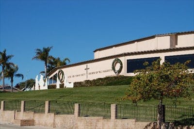 Building on a hill with a cross and wreaths on its side