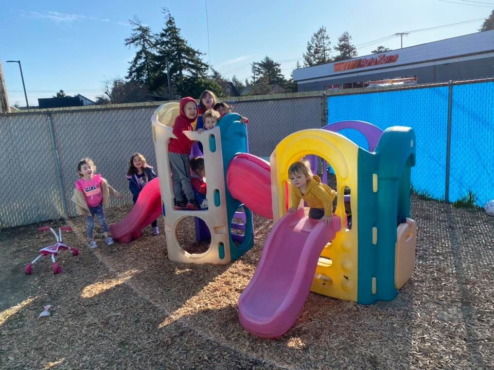 Children playing on a colorful playground structure with slides