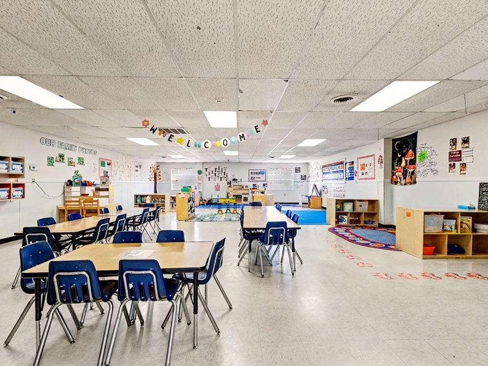 Classroom with tables and chairs, and a welcome banner
