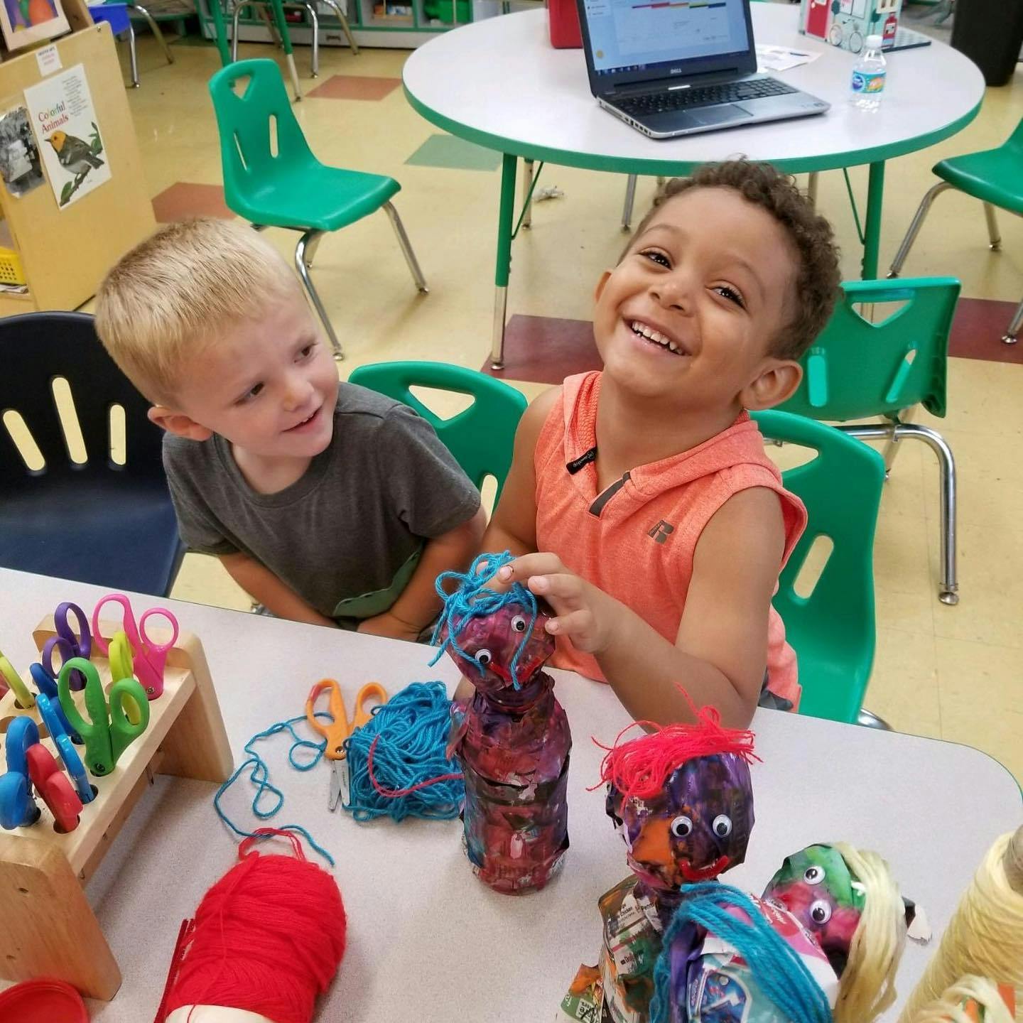 Two children at a table with crafts