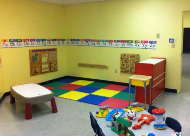Empty classroom with colorful floor mats and small tables