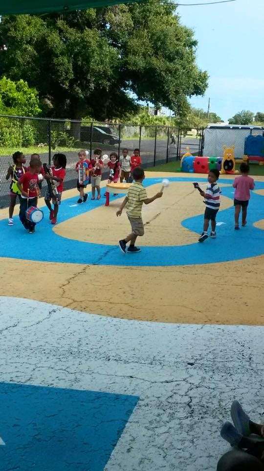 Children playing with toys on a painted outdoor surface