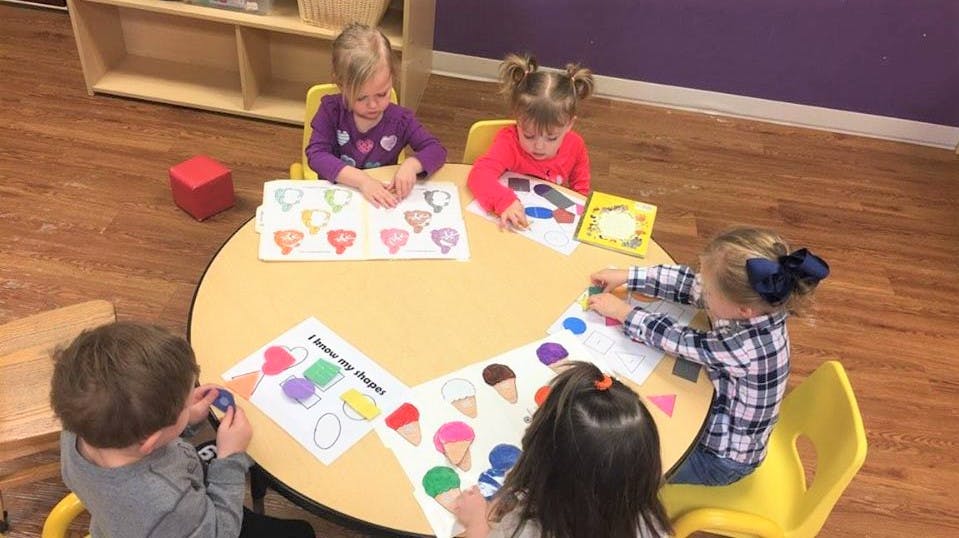 Four children at a table doing an activity with ice cream cutouts