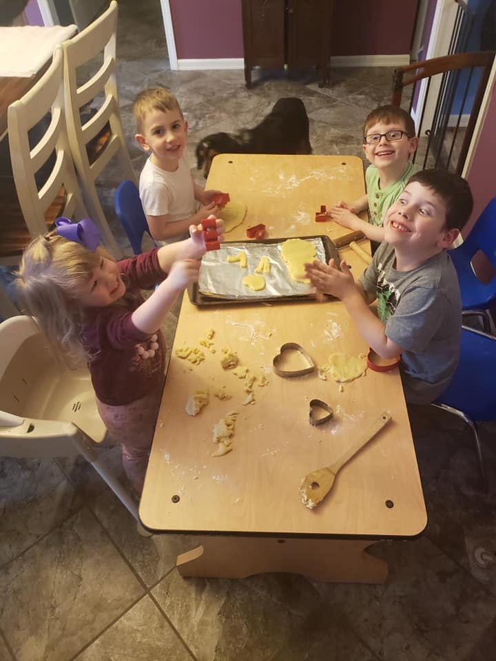 Four children making cookies at a table