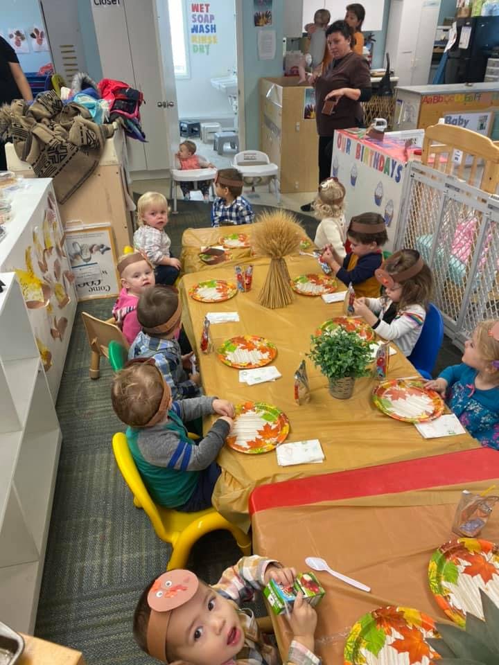 Children sitting at tables with fall-themed plates in a classroom