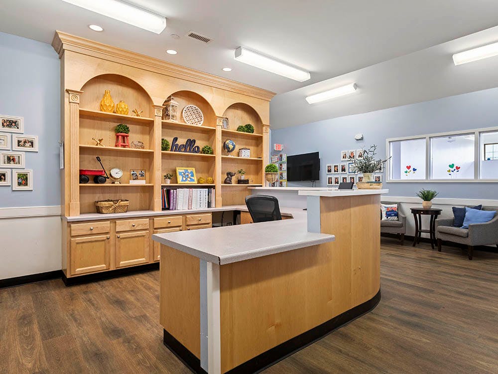 reception desk with shelves filled with decorative items and framed photos
