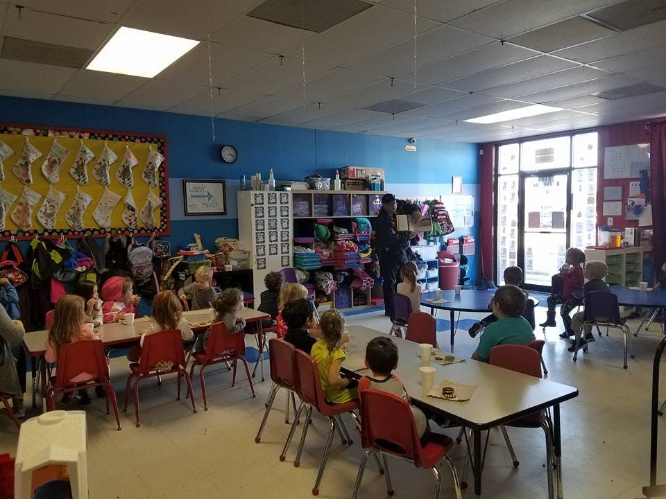 Children sitting at tables in a classroom