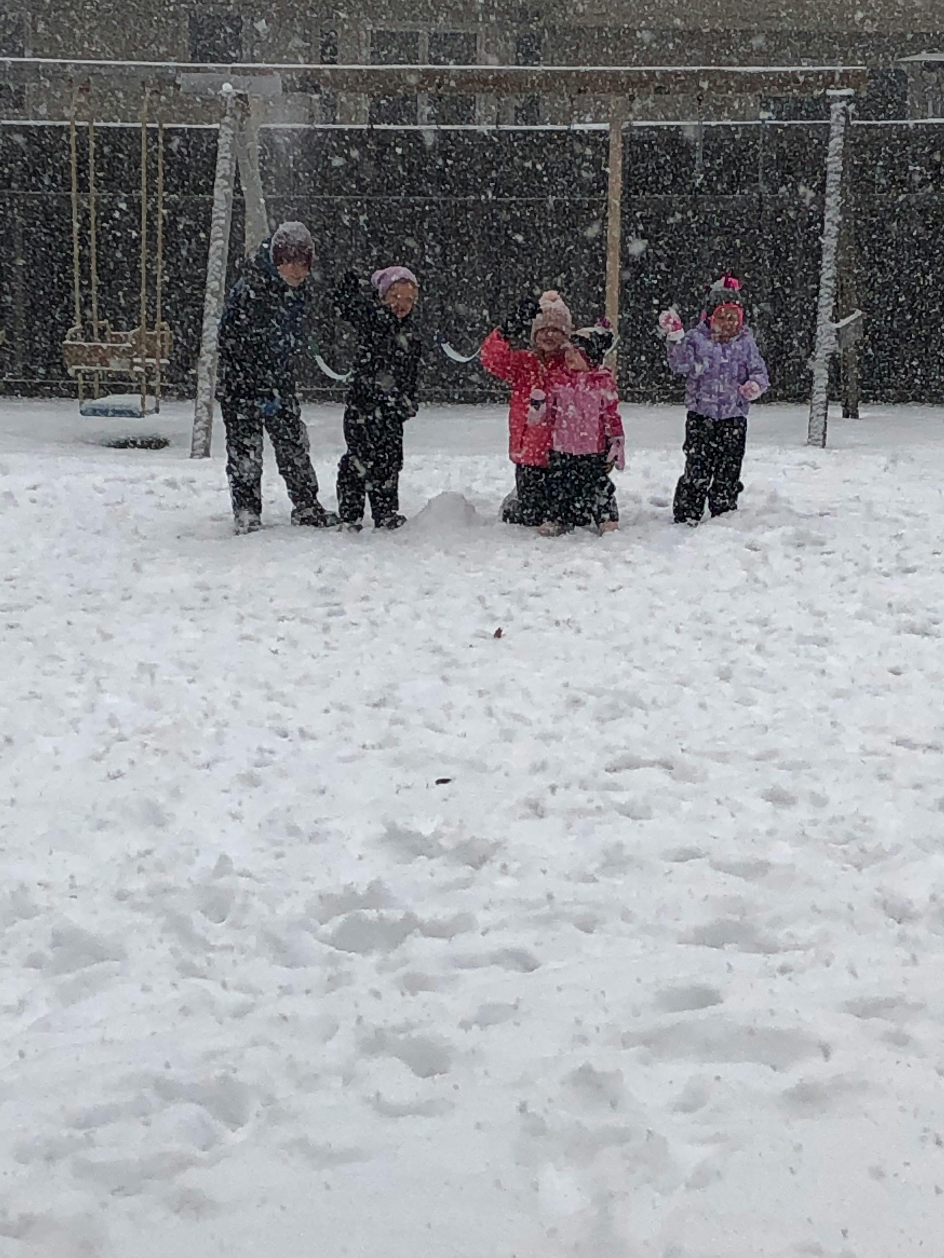Children playing in snow on a playground