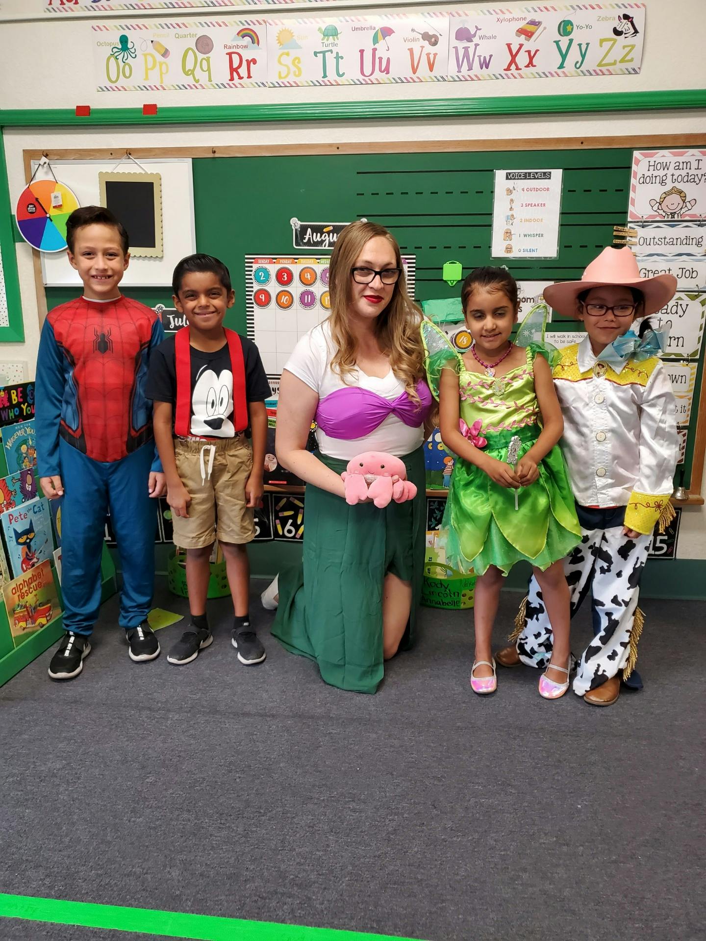 Adult and four children in costumes in a classroom