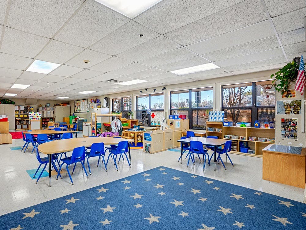 Empty classroom with tables, chairs, and learning materials