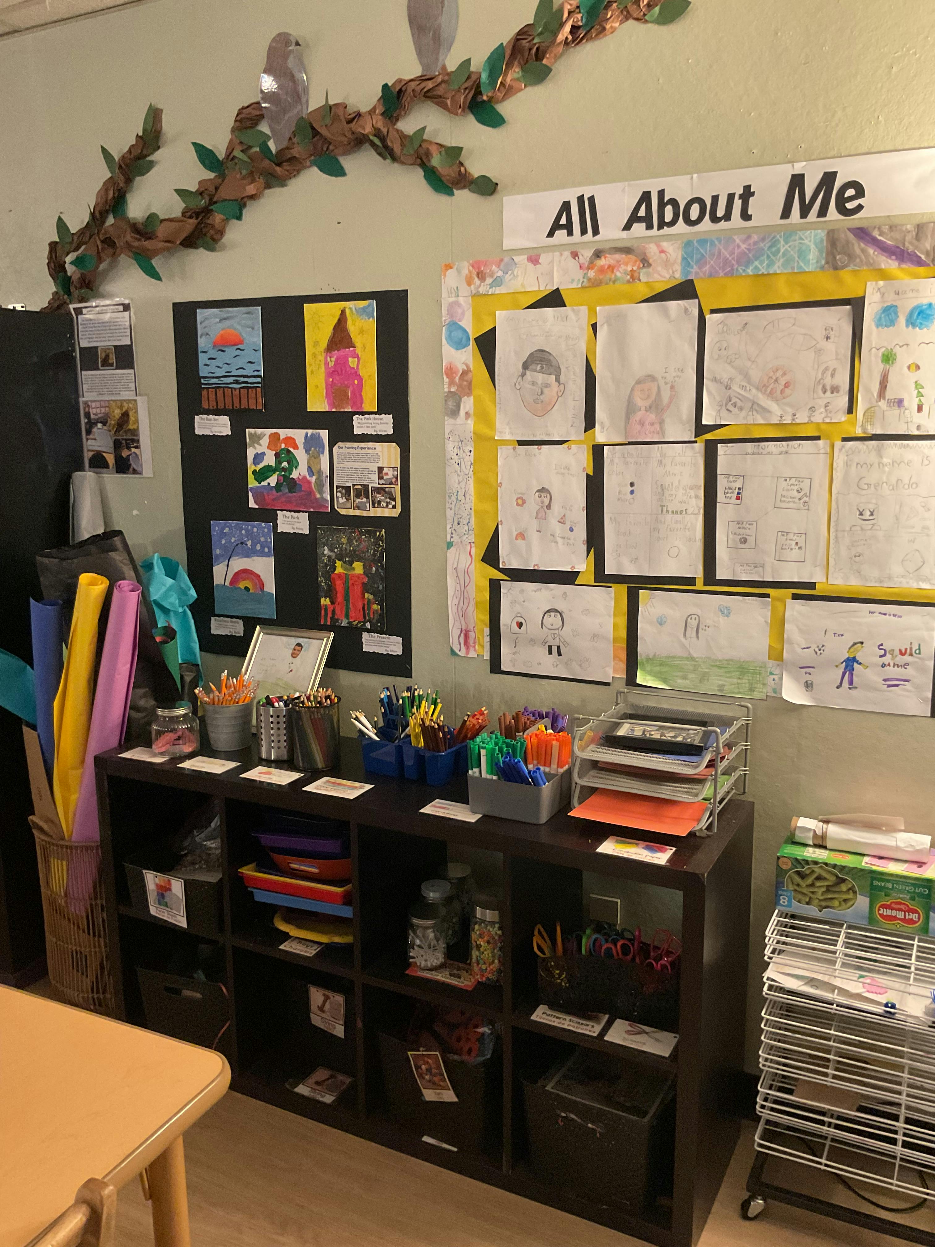 Classroom wall with children's artwork and an "All About Me" board