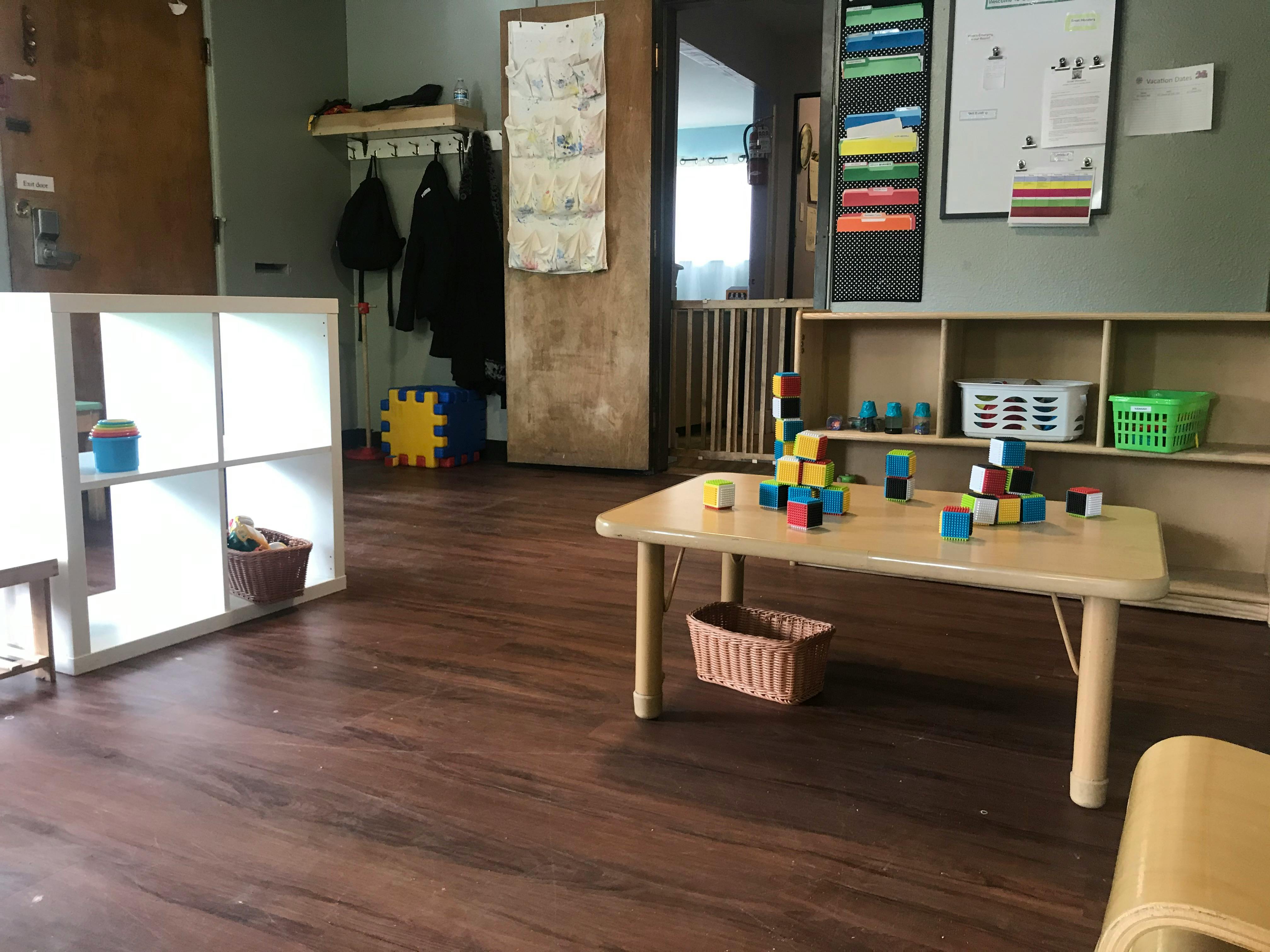Playroom with a table covered in blocks and shelves with toys