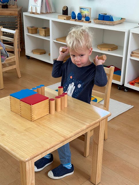 Child playing with wooden blocks at a table