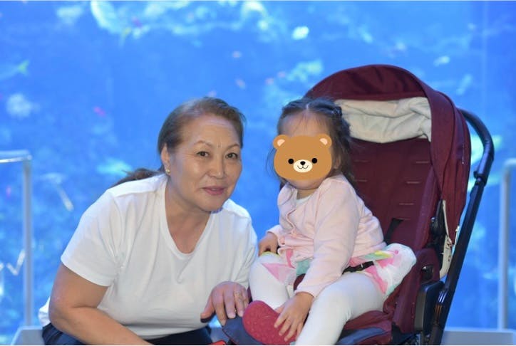 Person with a child in a stroller against a blue background