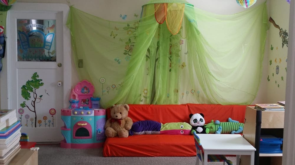 Child's room with red couch, stuffed animals, and play kitchen