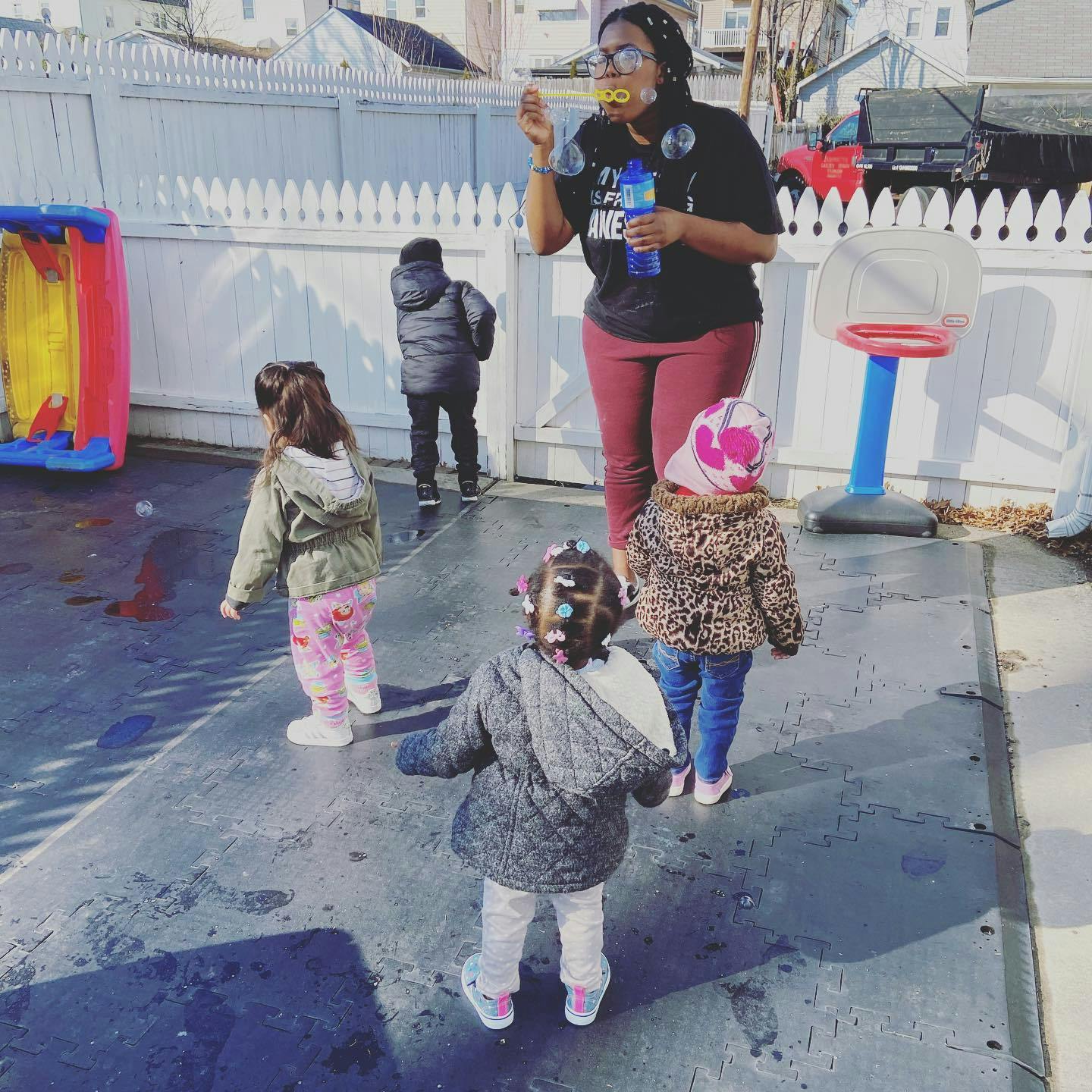 Person blowing bubbles for children outdoors