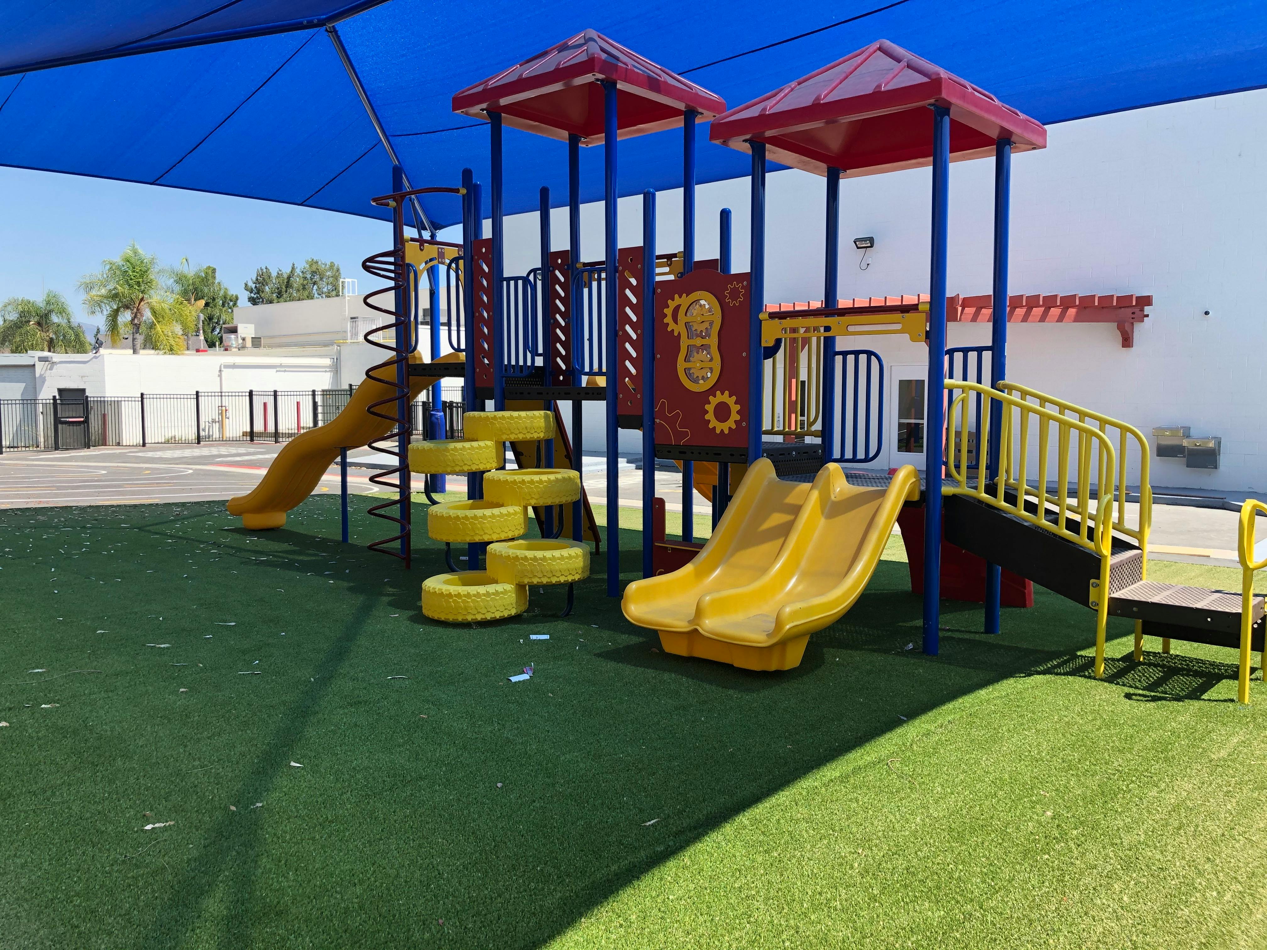 Playground with slides and climbing structures on green turf
