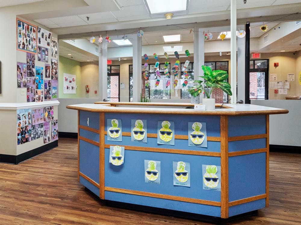 Reception desk with child artwork and collages on the walls