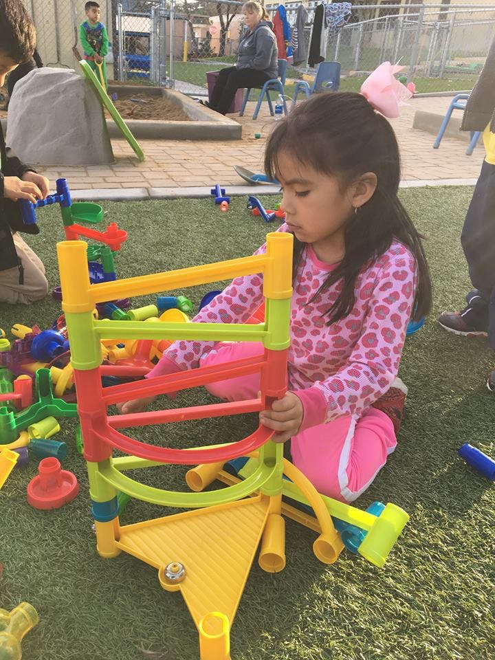 Child playing with a colorful toy on artificial grass