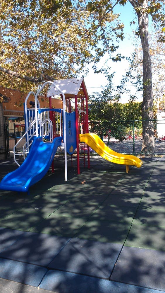 Playground with blue and yellow slides on soft ground