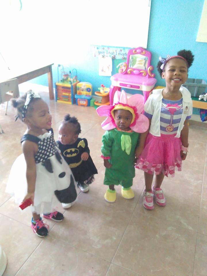 Four children in costumes standing in a room