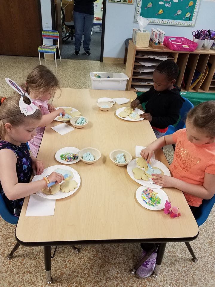 Children decorating cookies at a table