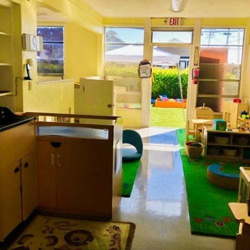 Indoor classroom with an open door leading to an outdoor play area