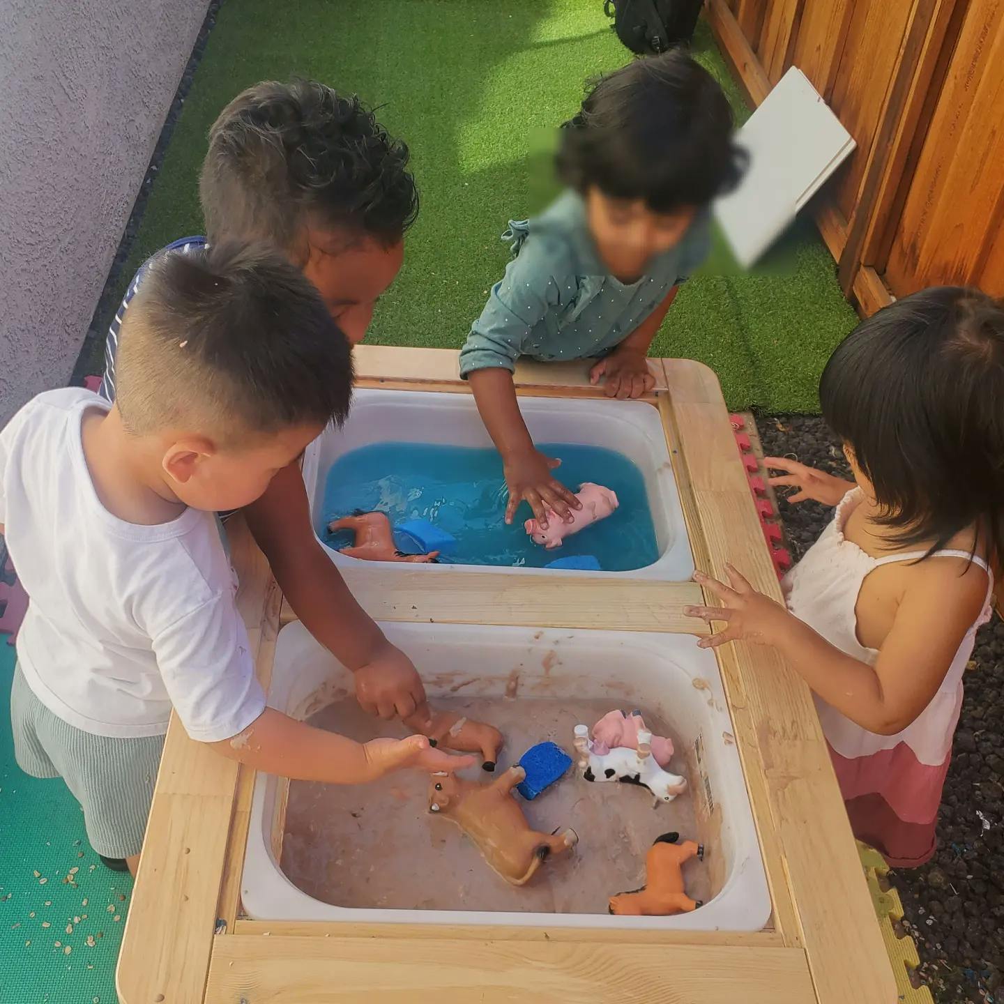 Children playing with water and sand in a sensory table
