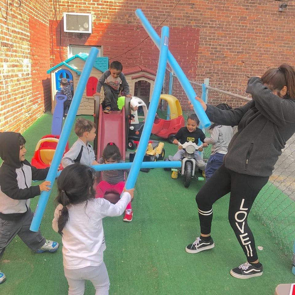 Adult and children playing with blue foam tubes on a playground