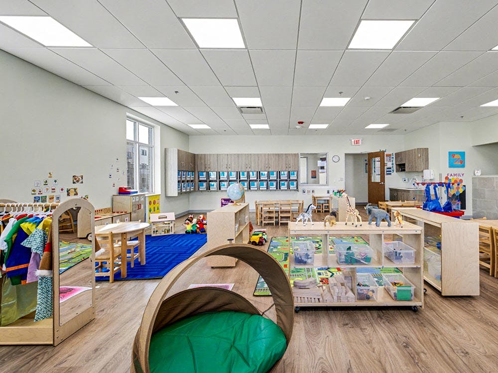 A classroom with child-sized furniture and colorful play areas
