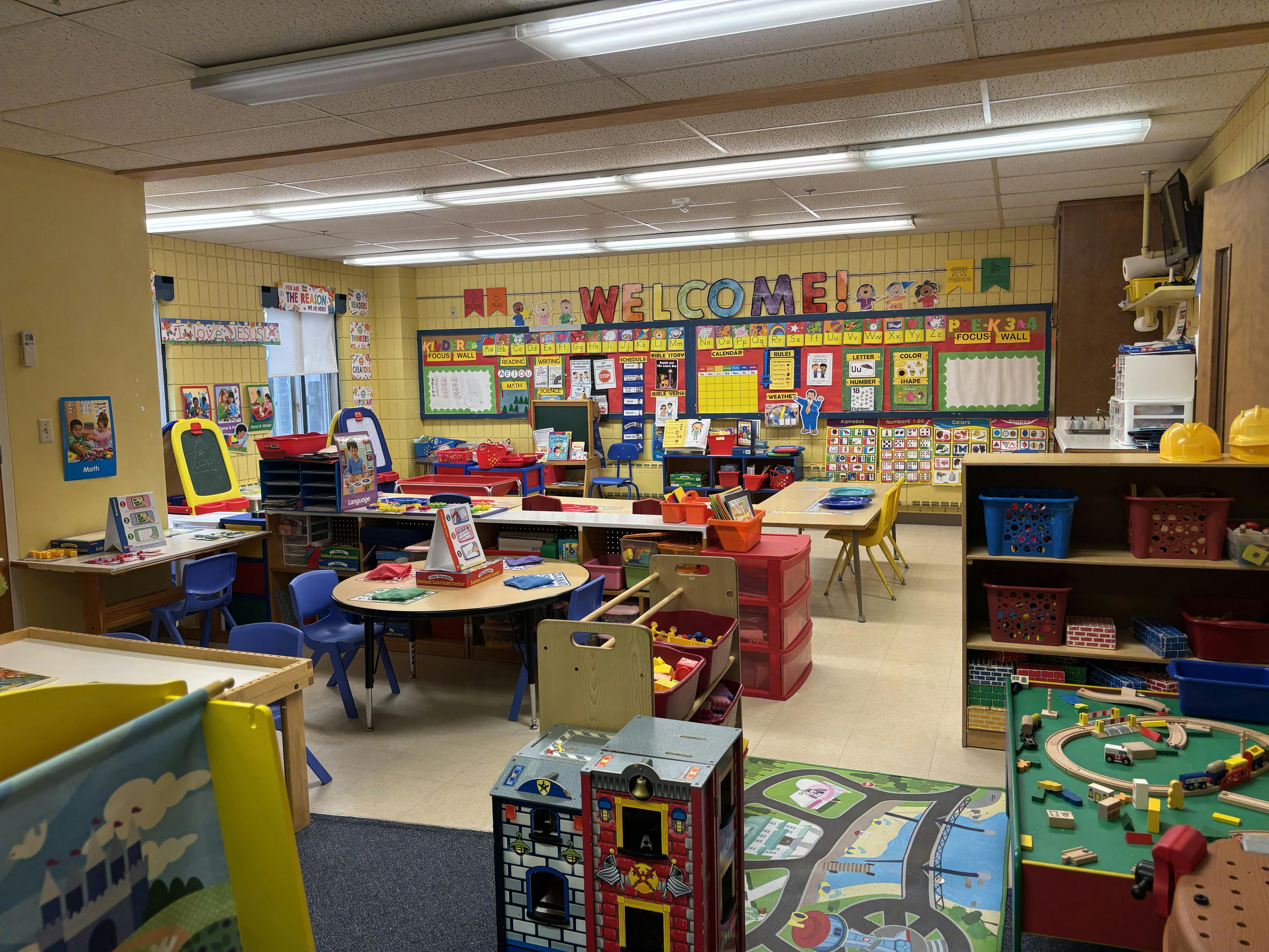 Empty preschool classroom with learning materials and activity tables