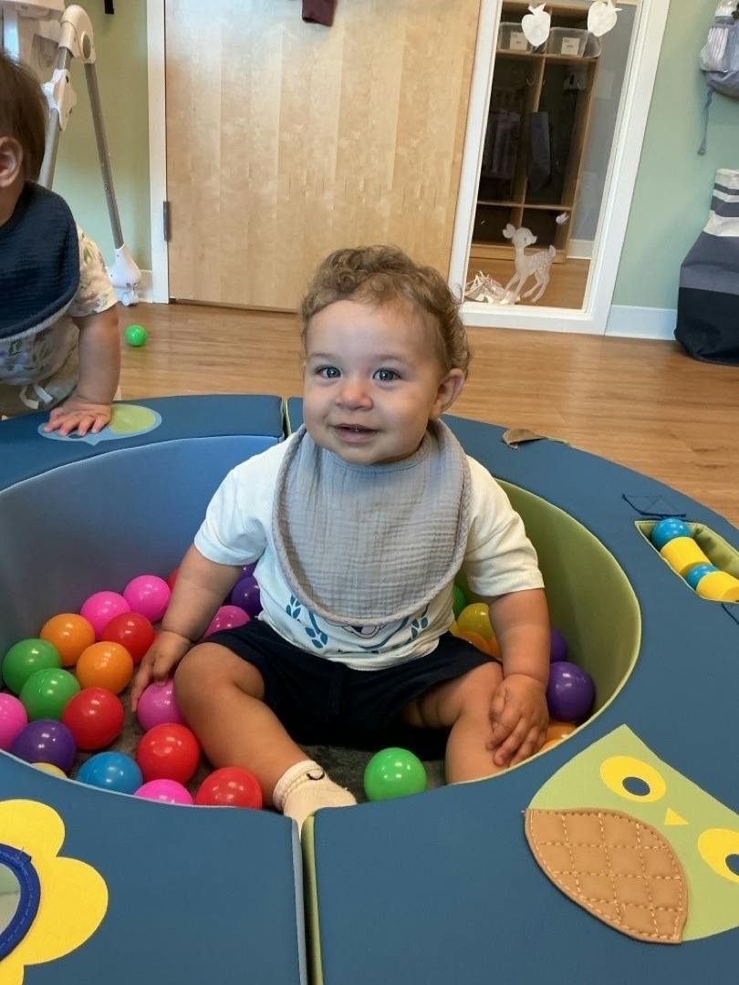 A child sitting in a small ball pit